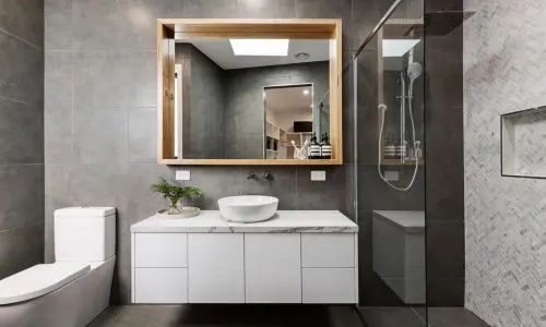 Modernes Badezimmer mit beleuchtetem Spiegel, stilvollen Armaturen und durchdachten Bad-Accessoires