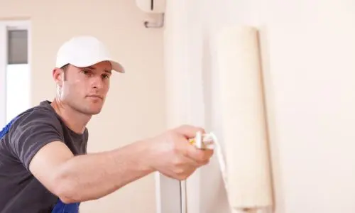 Maler streicht Innenwand eines Hauses in Mallorca
