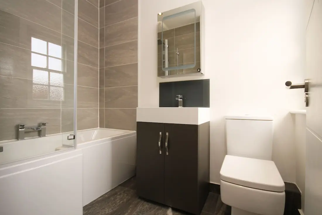 Teilrenoviertes kleines Bad mit moderner Badewanne, WC und Spiegelschrank