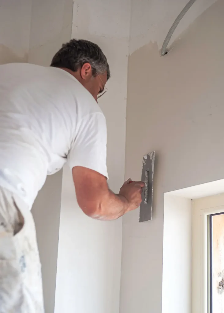 Handwerker führt Spachtelarbeiten an einer Gipskartonwand in Mallorca durch